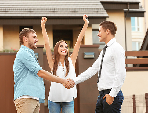 A happy couple in front of their newly purchased home